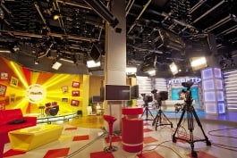 Television studio set lighting with Kino Flo lights on grid with pantographs